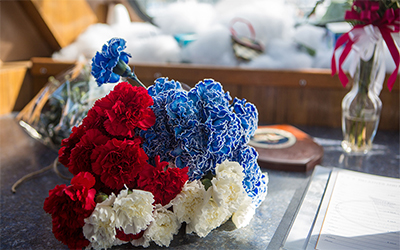 Close up of a flower bouquet on a boat during a ceremony for scattering ashes at sea.